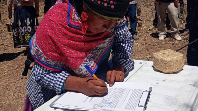 Mujer wixárika en firma de sustitución de tierras